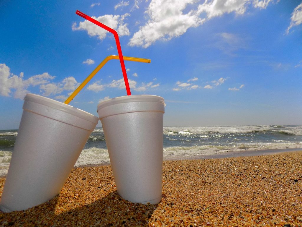 Two polystyrene cups on a beach