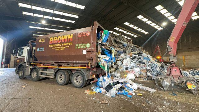 waste puring out of a bin collection truck ready for processing - Brown recycling